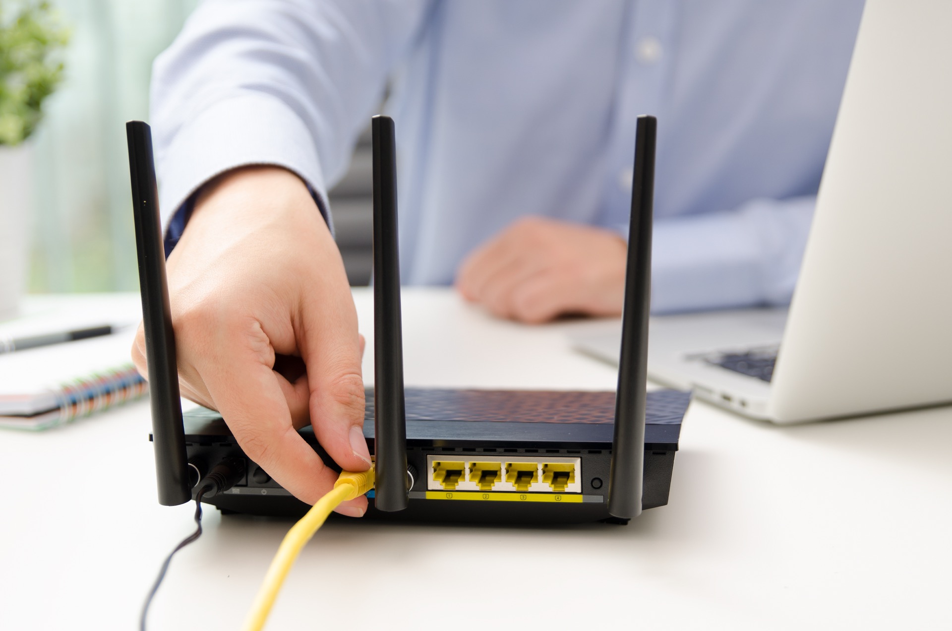 Man plugs Ethernet cable into router